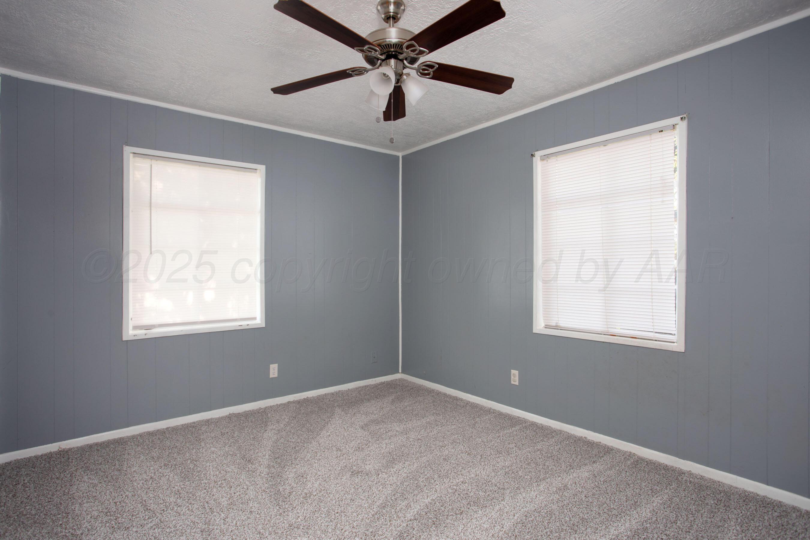 4630 South Hayden Street Amarillo, TX 79110 - Photo 16 of 26 an empty room with a window and a fan