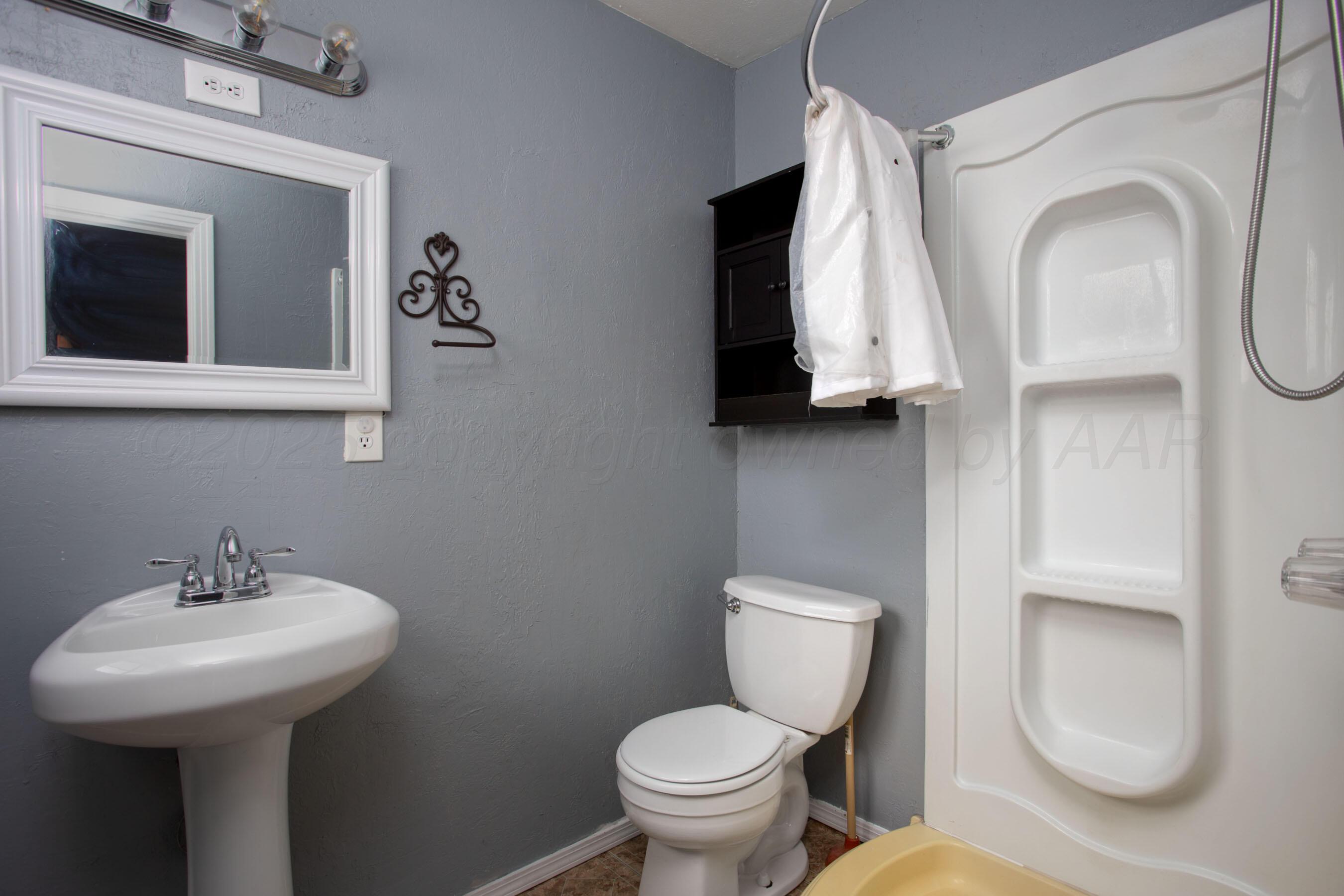 4630 South Hayden Street Amarillo, TX 79110 - Photo 20 of 26 a bathroom with a toilet sink and mirror