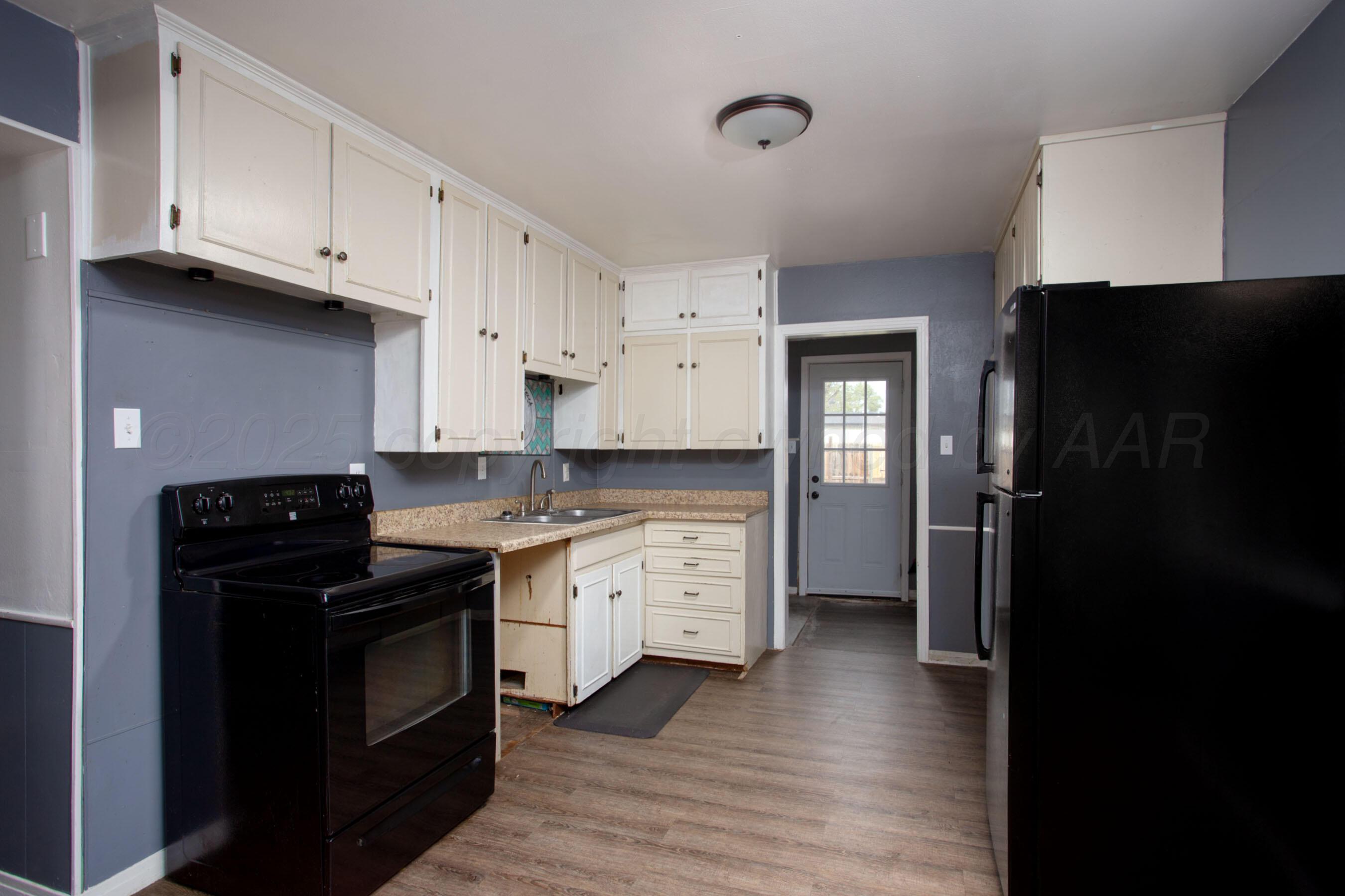 4630 South Hayden Street Amarillo, TX 79110 - Photo 10 of 26 a kitchen with granite countertop a refrigerator stove and sink