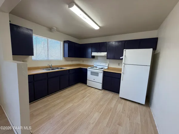 a kitchen with stainless steel appliances granite countertop a refrigerator sink a microwave and cabinets