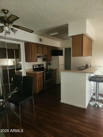 a kitchen with stainless steel appliances kitchen island granite countertop a stove a sink a refrigerator and chairs