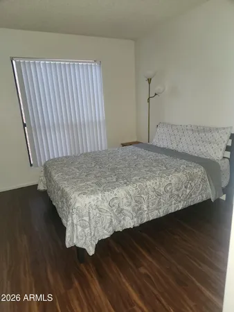a bedroom with a bed and wooden floor