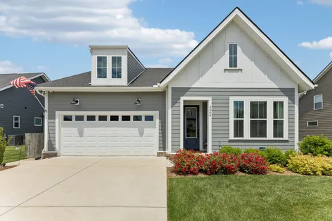a front view of a house with a yard and potted plants