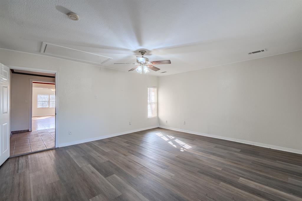1107 Ferndale Avenue Dallas, TX 75224 - Photo 11 of 20 a view of an empty room with wooden floor and a window