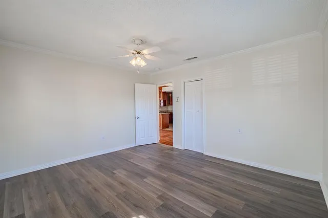 a view of empty room with wooden floor