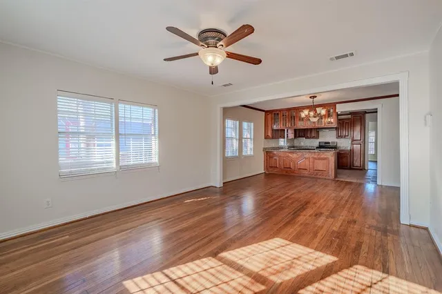 a living room with stainless steel appliances kitchen island hardwood floor and a window