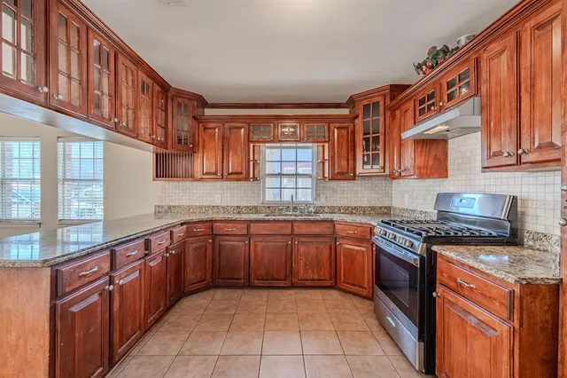 a large kitchen with stainless steel appliances granite countertop a stove sink and cabinets