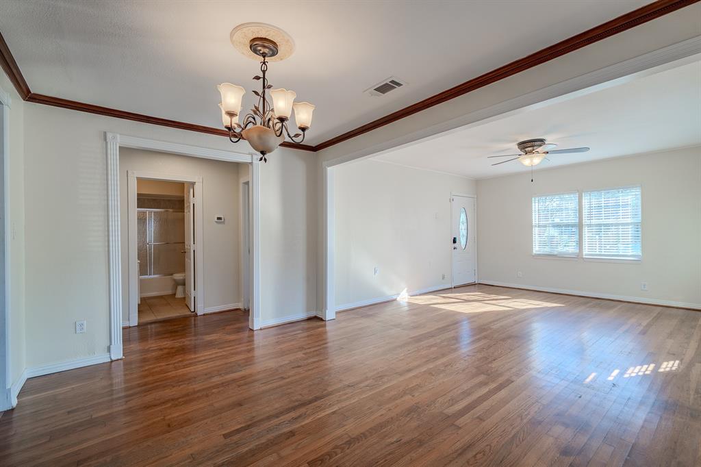 1107 Ferndale Avenue Dallas, TX 75224 - Photo 9 of 20 a view of an empty room with wooden floor and a window