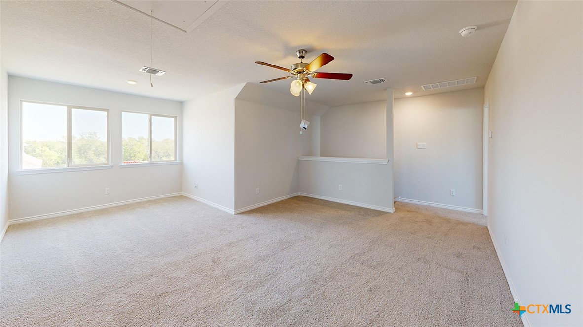 14096 Carsten Loop Salado, TX 76571 - Photo 21 of 32 an empty room with windows and ceiling fan