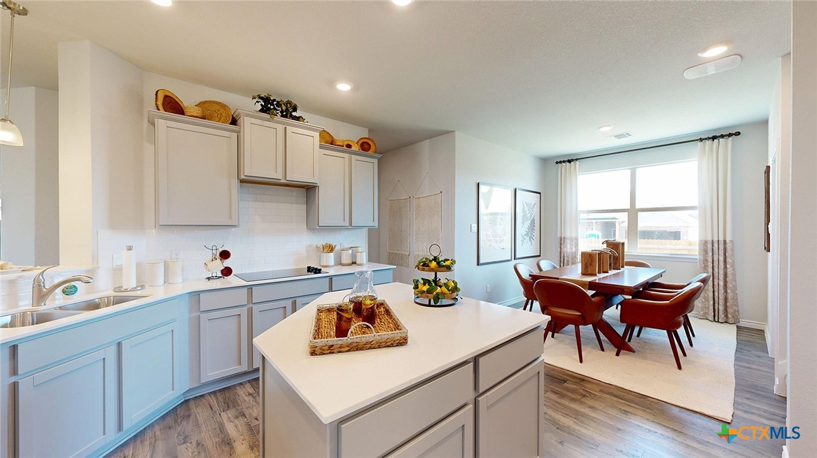 14096 Carsten Loop Salado, TX 76571 - Photo 7 of 32 a kitchen that has a sink a table and chairs in it