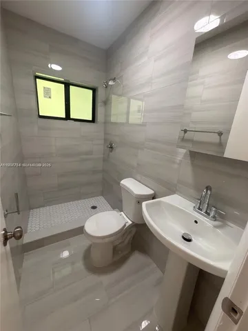 a bathroom with a toilet a sink and mirror