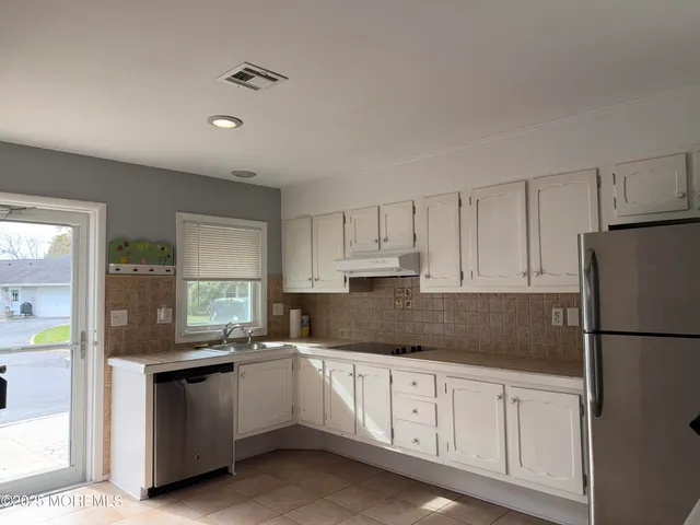 a kitchen with granite countertop white cabinets white stainless steel appliances and sink