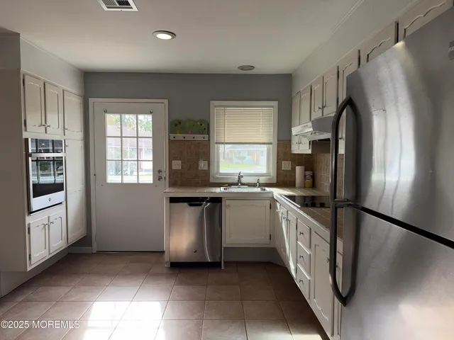 a kitchen with a sink a refrigerator and window