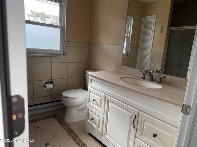 a bathroom with a granite countertop toilet sink and mirror