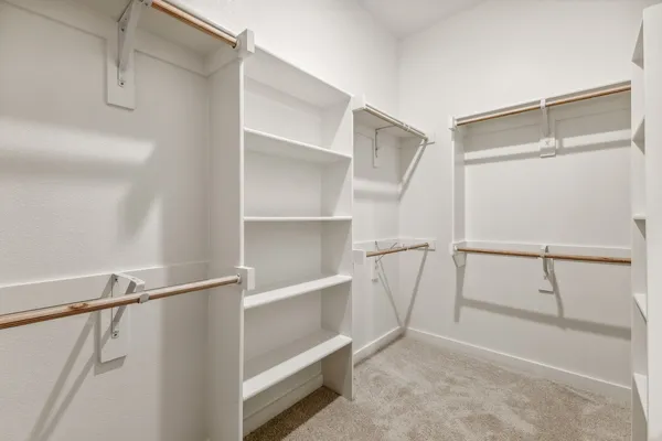 a view of walk in closet with empty racks