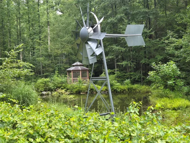 a backyard of a house with a garden and covered with tall trees