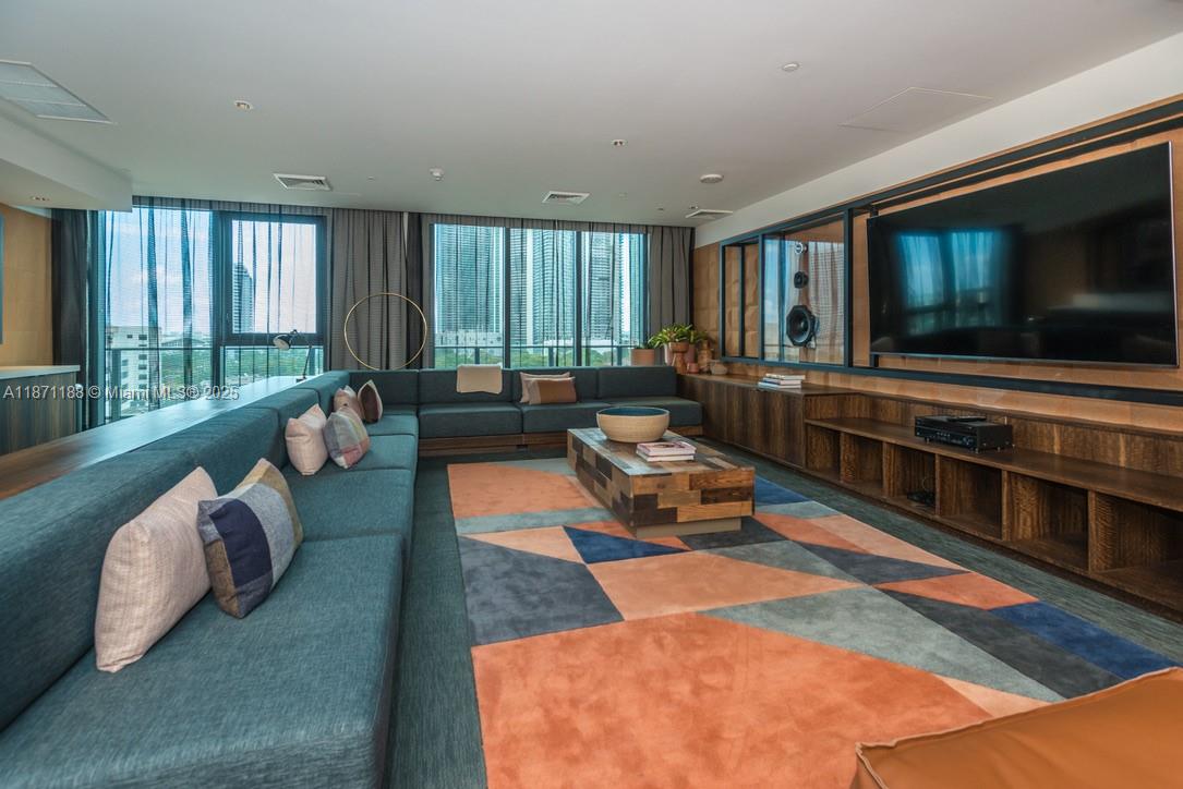 121 Northeast 34th Street, Unit 901 Miami, FL 33137 - Photo 19 of 29 a living room with furniture and a flat screen tv