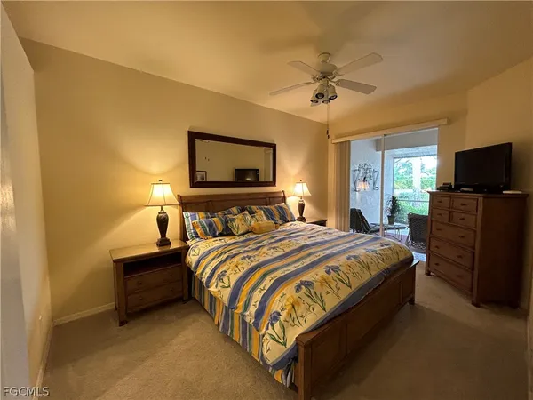 a bedroom with bed tv and dresser