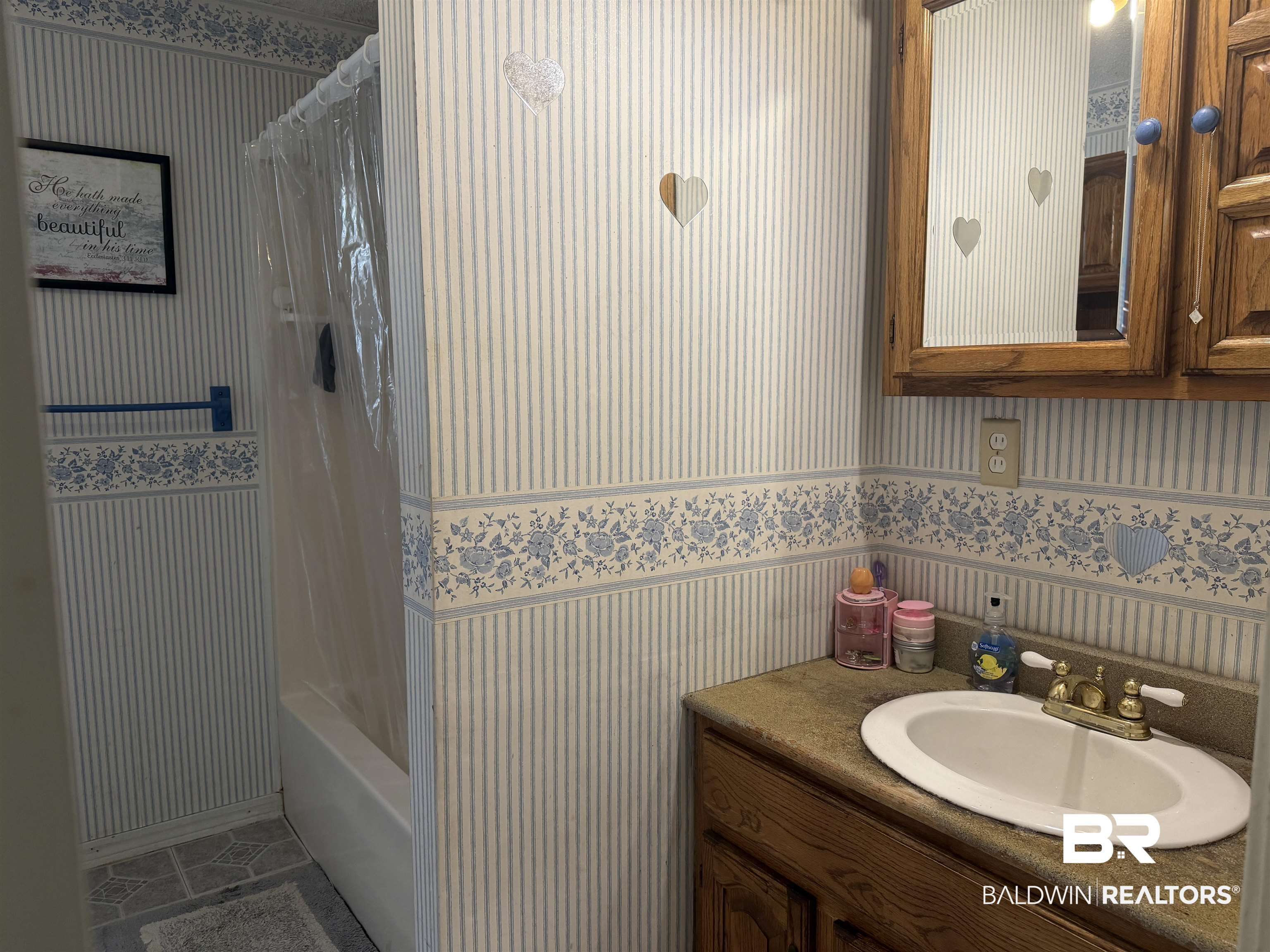 1401 East Forest Ridge Road Mobile, AL 36618 - Photo 14 of 19 Bathroom featuring a vanity with a white oval sink, brass-finish faucet, and a mirror-front medicine cabinet
