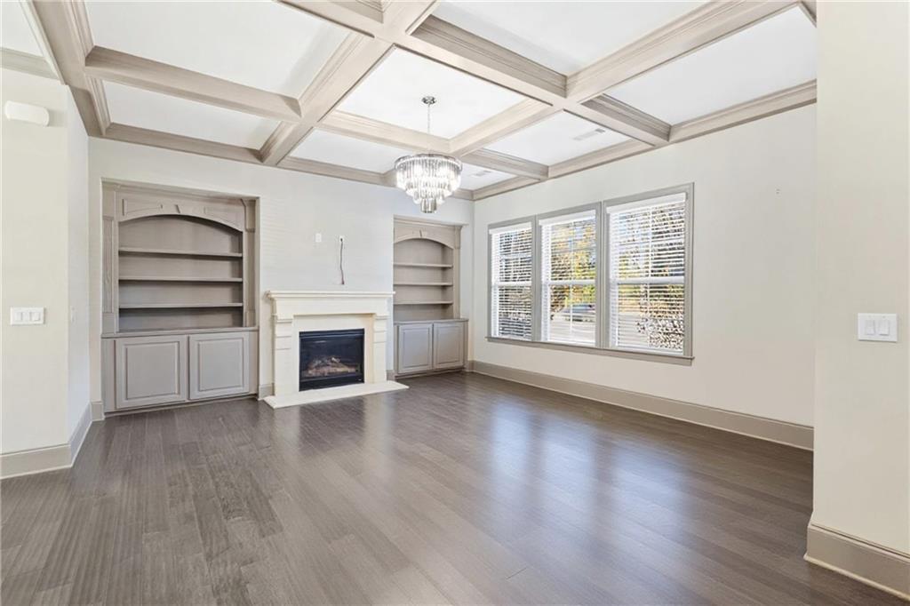 1802 Stephanie Trail Northeast Atlanta, GA 30329 - Photo 21 of 25 an empty room with wooden floor fireplace and windows