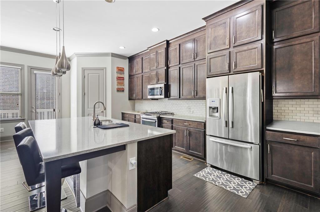 1802 Stephanie Trail Northeast Atlanta, GA 30329 - Photo 4 of 25 a kitchen with stainless steel appliances granite countertop a refrigerator a sink dishwasher a stove with white cabinets and wooden floor