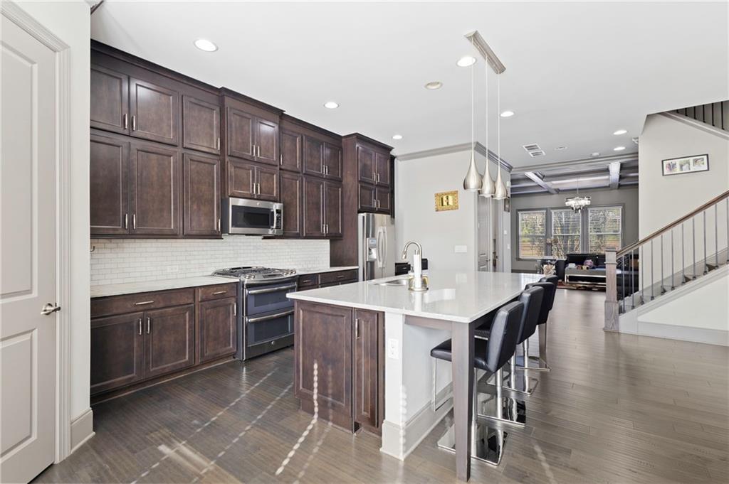 1802 Stephanie Trail Northeast Atlanta, GA 30329 - Photo 6 of 25 a kitchen with stainless steel appliances granite countertop a table chairs sink and cabinets