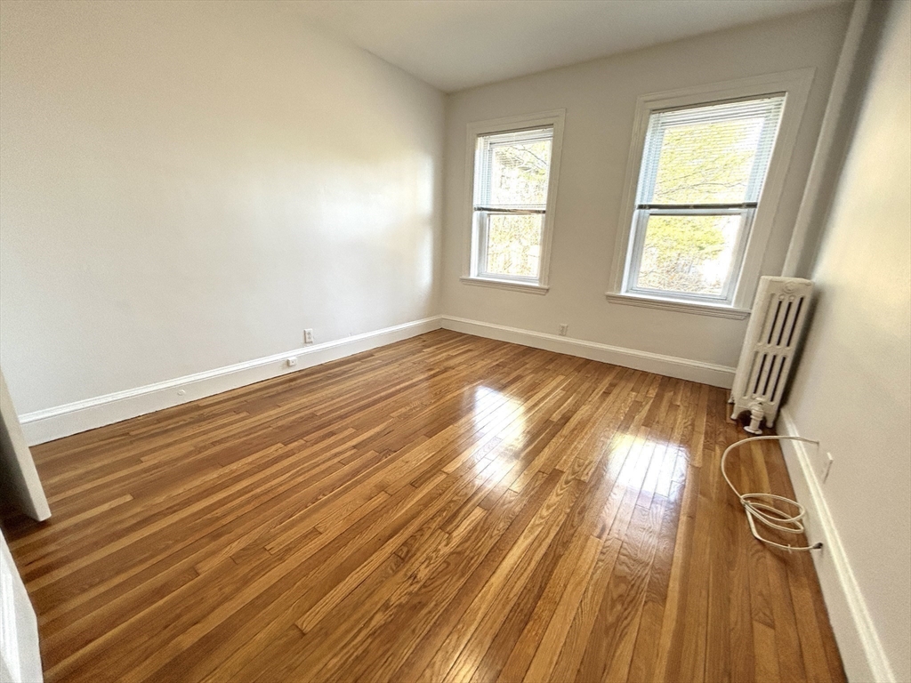 1666 Commonwealth Avenue, Unit 24 Boston, MA 02135 - Photo 12 of 16 a view of empty room with wooden floor and fan