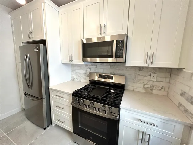 a kitchen with stainless steel appliances a refrigerator stove and microwave