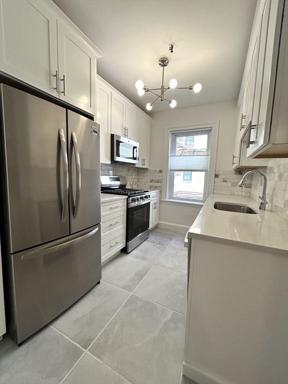 1666 Commonwealth Avenue, Unit 24 Boston, MA 02135 - Photo 3 of 16 a kitchen with granite countertop stainless steel appliances a refrigerator cabinets and a sink
