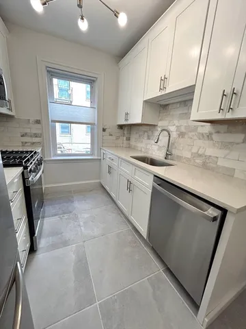 a kitchen with a sink a stove and cabinets