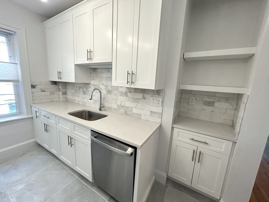 1666 Commonwealth Avenue, Unit 24 Boston, MA 02135 - Photo 5 of 16 a kitchen with white cabinets and white appliances