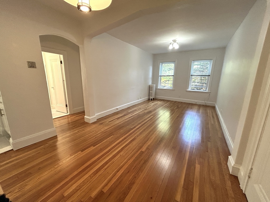 1666 Commonwealth Avenue, Unit 24 Boston, MA 02135 - Photo 9 of 16 an empty room with wooden floor and windows