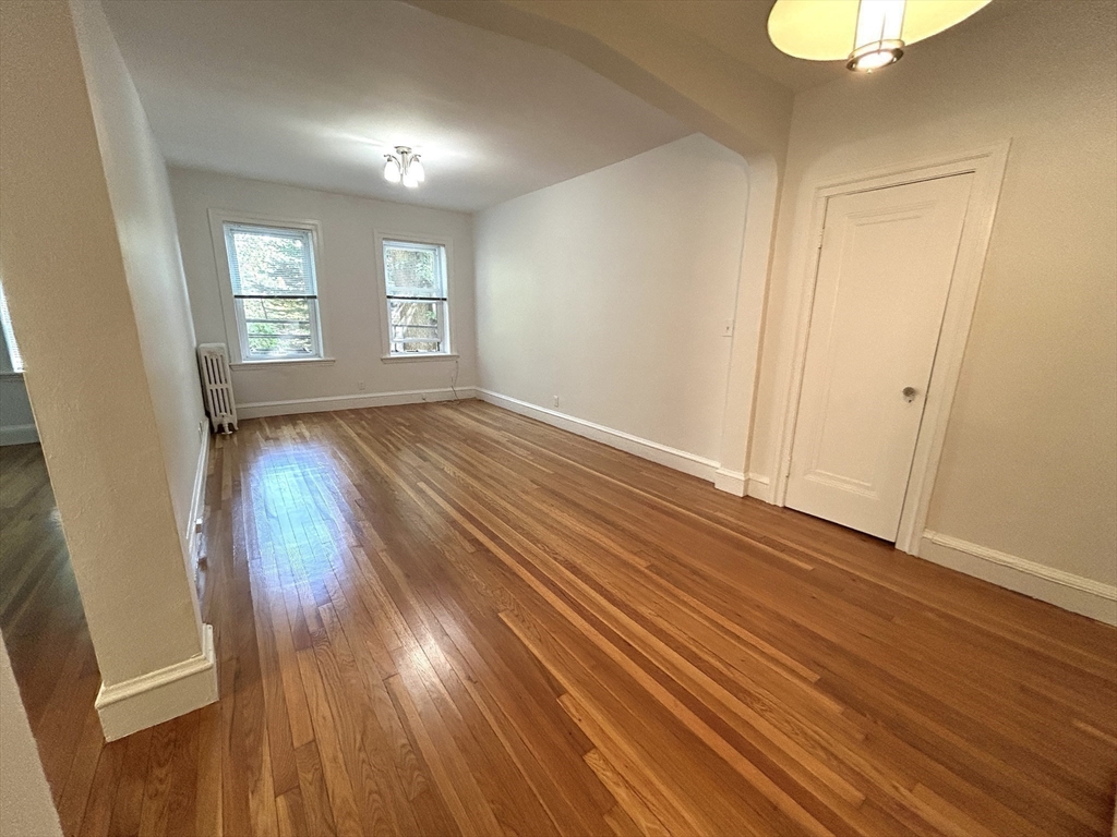 1666 Commonwealth Avenue, Unit 24 Boston, MA 02135 - Photo 10 of 16 an empty room with wooden floor and windows