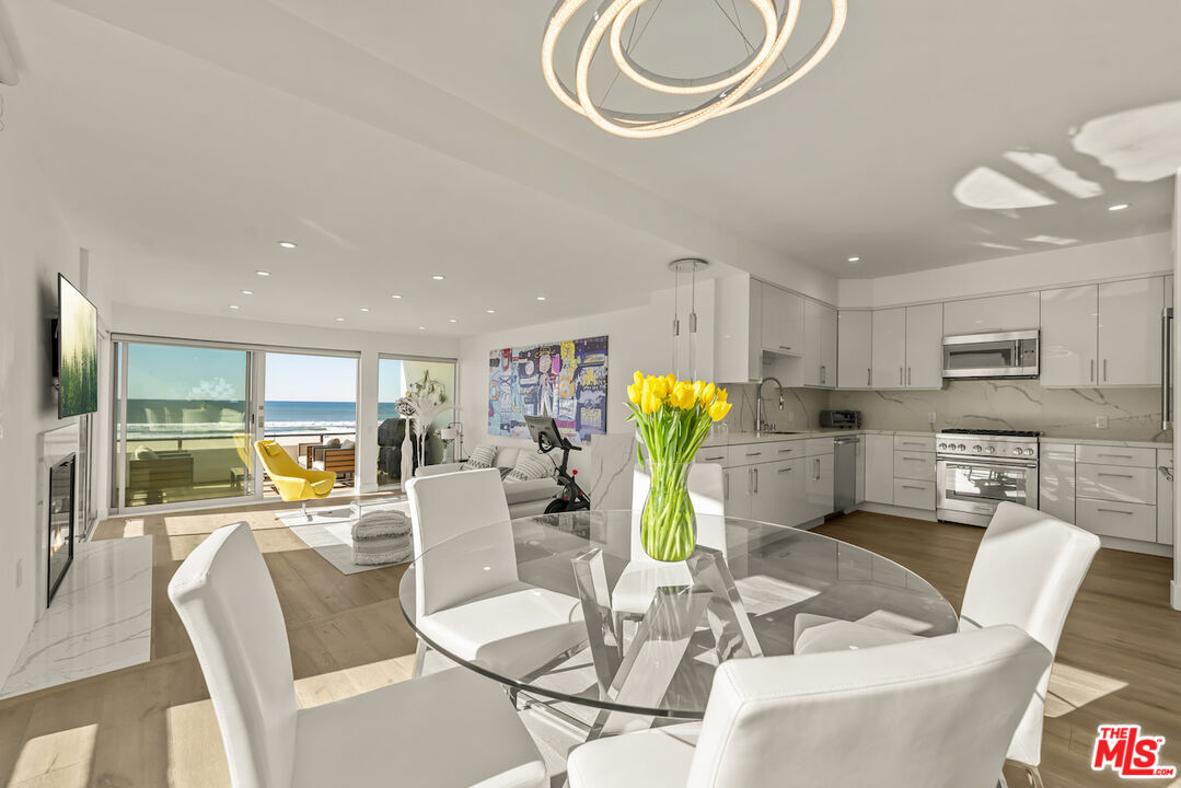 a kitchen with stainless steel appliances kitchen island granite top table and chairs