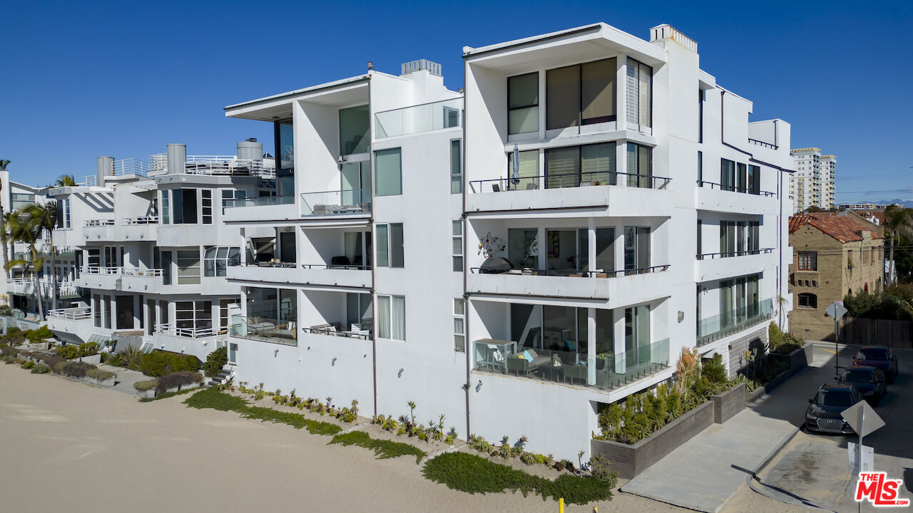 1 Eastwind Street, Unit 201 Marina del Rey, CA 90292 - Photo 2 of 40 a front view of a building with glass windows and a yard