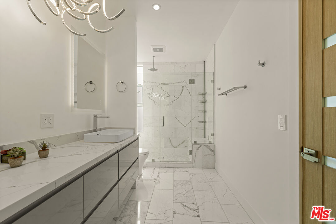 1 Eastwind Street, Unit 201 Marina del Rey, CA 90292 - Photo 26 of 40 a bathroom with a granite countertop sink mirror and shower