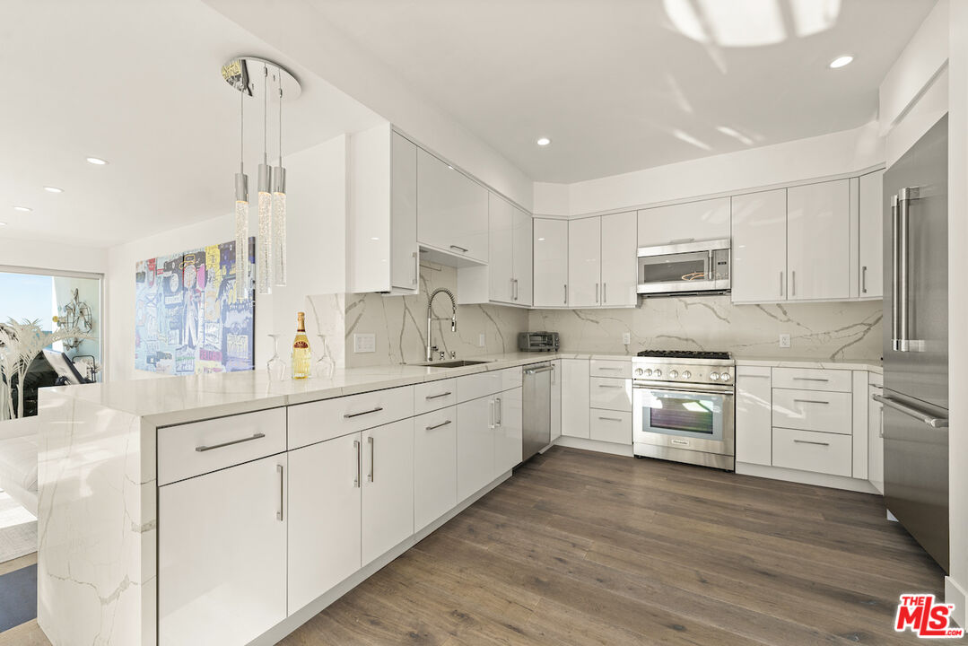 1 Eastwind Street, Unit 201 Marina del Rey, CA 90292 - Photo 4 of 40 a kitchen with white cabinets sink and stainless steel appliances