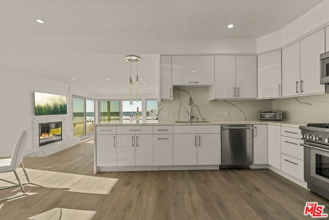 1 Eastwind Street, Unit 201 Marina del Rey, CA 90292 - Photo 6 of 40 a kitchen with granite countertop a stove top oven sink and cabinets