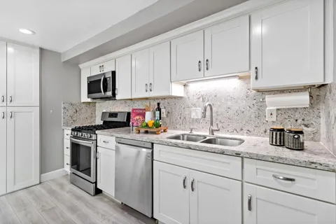 a kitchen with white cabinets and white appliances