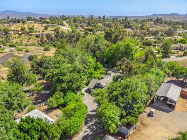 an aerial view of residential house with outdoor space and trees all around