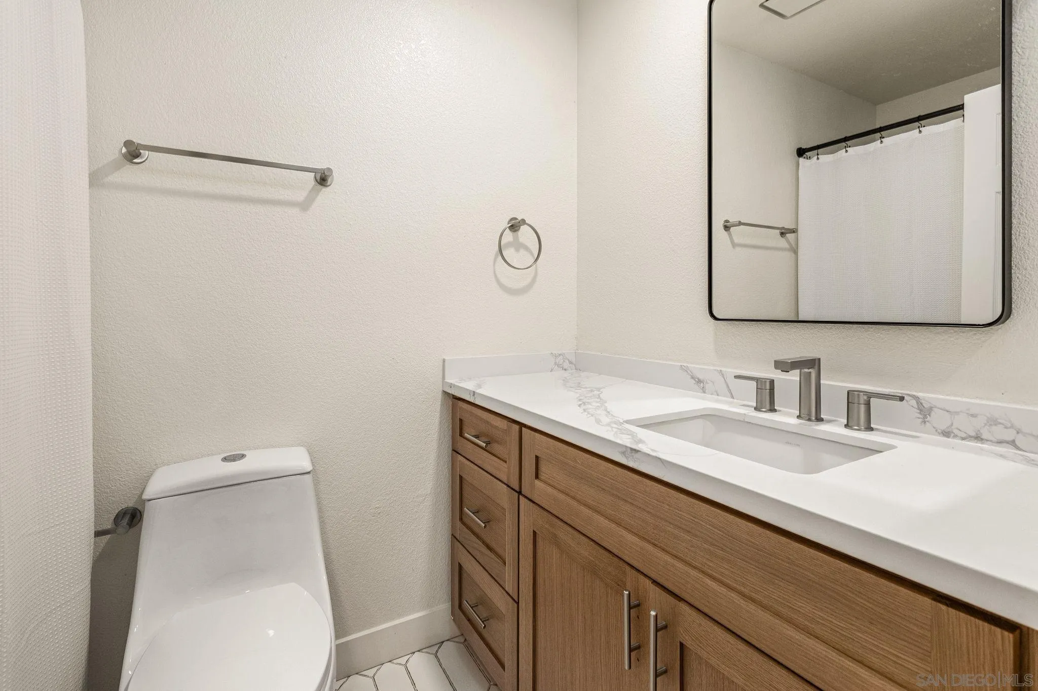 2029 Winterwarm Drive Fallbrook, CA 92028 - Photo 33 of 36 a bathroom with a granite countertop sink a toilet and a mirror
