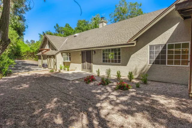 a backyard of a house with table and chairs
