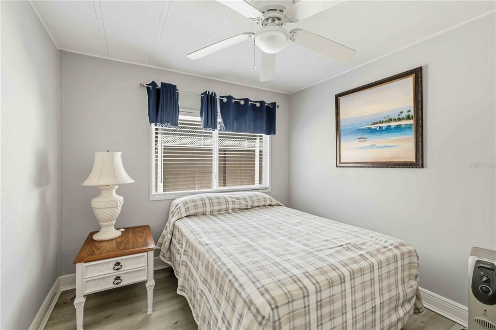 10303 Burnt Store Road, Unit 54 Punta Gorda, FL 33950 - Photo 13 of 27 a bedroom with a large bed and a chandelier