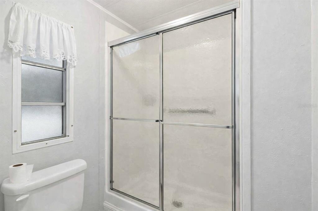 10303 Burnt Store Road, Unit 54 Punta Gorda, FL 33950 - Photo 17 of 27 a bathroom with a glass shower door