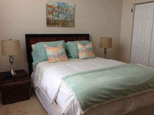 a large bed sitting in a bedroom next to a window