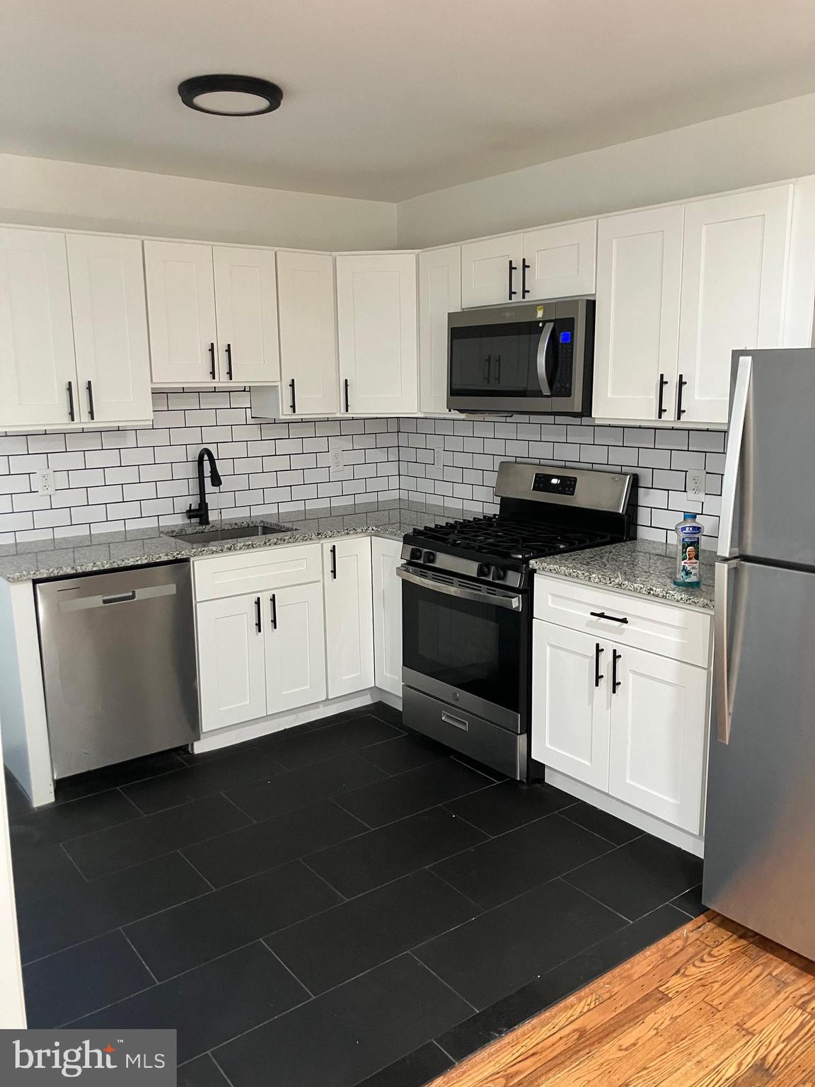 3014 Memphis Street Philadelphia, PA 19134 - Photo 5 of 15 a kitchen with granite countertop a sink cabinets and stainless steel appliances