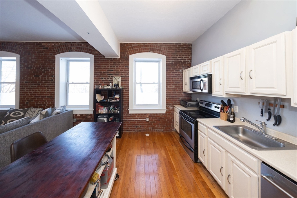 32 Providence Street, Unit 5 Worcester, MA 01604 - Photo 2 of 42 a kitchen with wooden floors and stainless steel appliances