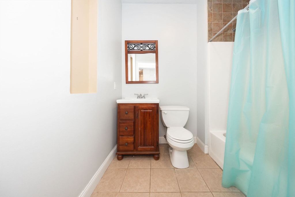 32 Providence Street, Unit 5 Worcester, MA 01604 - Photo 21 of 42 a white toilet sitting next to a white sink and vanity