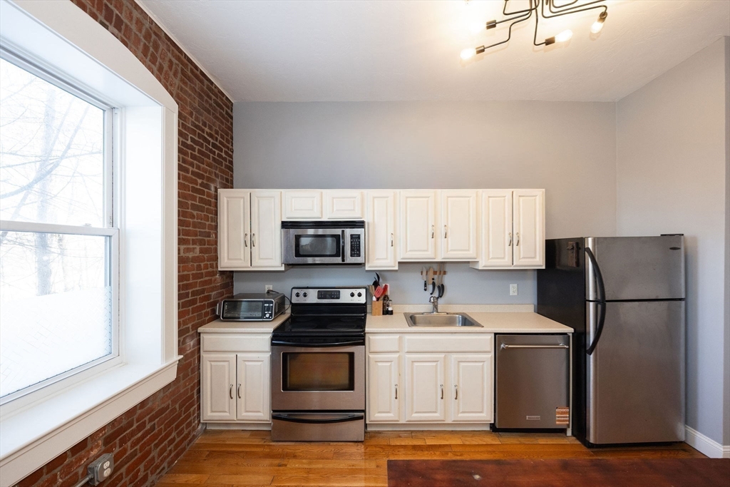 32 Providence Street, Unit 5 Worcester, MA 01604 - Photo 5 of 42 a kitchen with a refrigerator stove and microwave