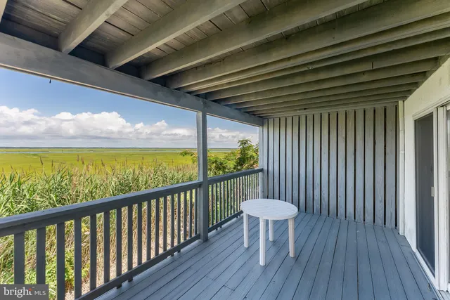 a view of a porch with furniture and a yard